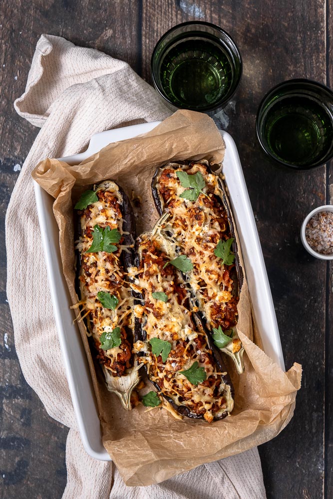 Gevulde aubergine, aubergine gevuld met zoete aardappel, rijst en linzen in een kruidige tomatensaus. Dit is een heerlijk vegetarisch zomer gerecht bomvol smaak! De aubergine rooster je in de oven of op de BBQ en vul je daarna met lekker veel groenten. Even aftoppen met verkruimelde feta en wat geraspte kaas en je hebt een heerlijk recept voor gevulde aubergine!