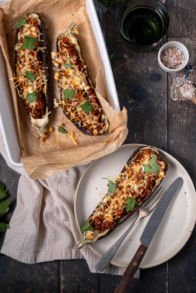 Gevulde aubergine, aubergine gevuld met zoete aardappel, rijst en linzen in een kruidige tomatensaus. Dit is een heerlijk vegetarisch zomer gerecht bomvol smaak! De aubergine rooster je in de oven of op de BBQ en vul je daarna met lekker veel groenten. Even aftoppen met verkruimelde feta en wat geraspte kaas en je hebt een heerlijk recept voor gevulde aubergine!