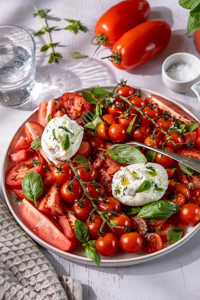 Tomatensalade met burrata. Een recept voor frisse, gezonde, zomerse salade met smaakvolle tomaten, een Italiaanse dressing en romige burrata.