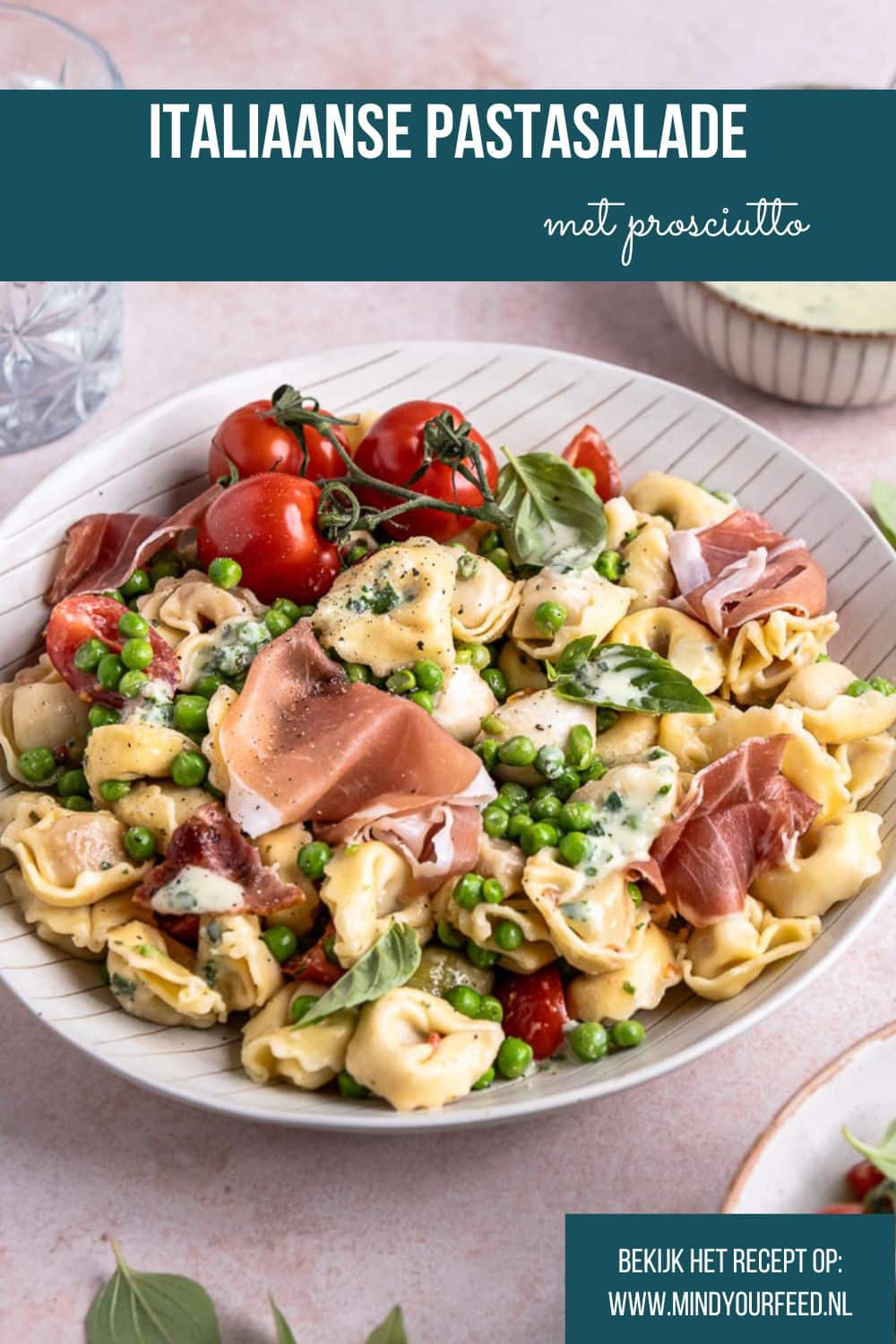 taliaanse pastasalade met prosciutto, mozzarella, tomaatjes, olijven, pancetta en doperwtjes, geserveerd met een frisse balsamico dressing en verse basilicum.