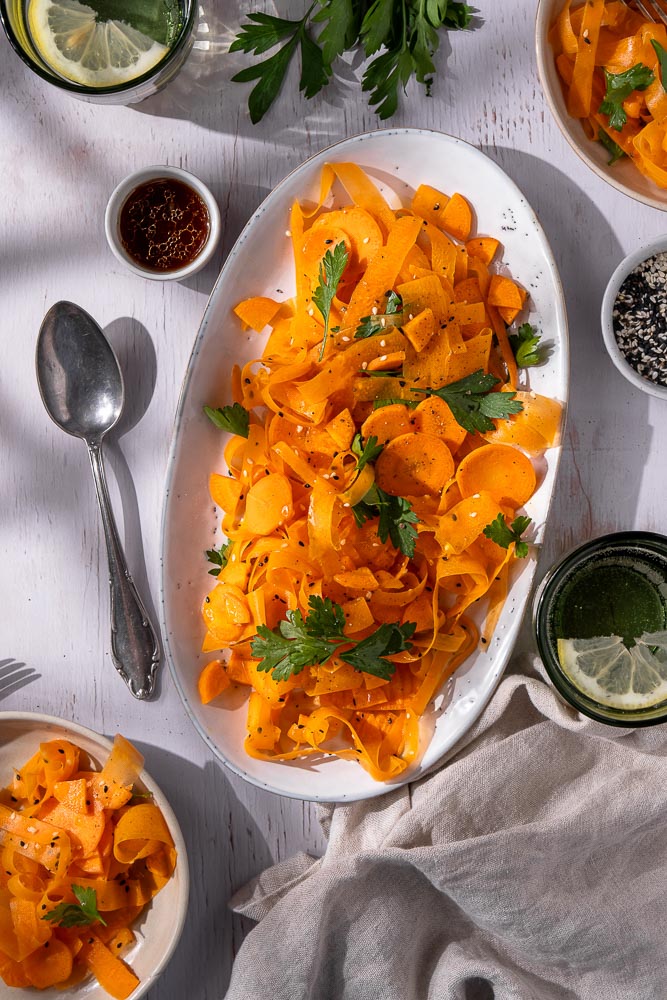 Frisse wortel salade met een Oosterse dressing van sesamolie, rijstazijn, maple syrup en sojasaus, gegarneerd met koriander en sesamzaadjes. Een gezonde, knapperige salade die perfect past bij een BBQ of als lichte lunch. Tiktok viral recept