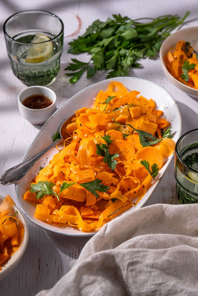 Frisse wortel salade met een Oosterse dressing van sesamolie, rijstazijn, maple syrup en sojasaus, gegarneerd met koriander en sesamzaadjes. Een gezonde, knapperige salade die perfect past bij een BBQ of als lichte lunch. Tiktok viral recept