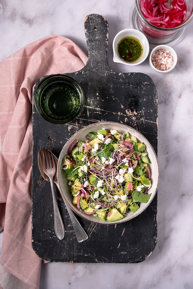 Makkeiljk recept voor gezonde avocado salade met komkommer, feta, verse munt en zoetzure rode ui, geserveerd met een frisse citroendressing, perfect als bijgerecht of lichte lunch.