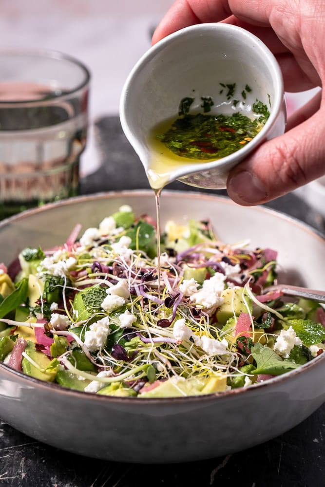 Makkeiljk recept voor gezonde avocado salade met komkommer, feta, verse munt en zoetzure rode ui, geserveerd met een frisse citroendressing, perfect als bijgerecht of lichte lunch.