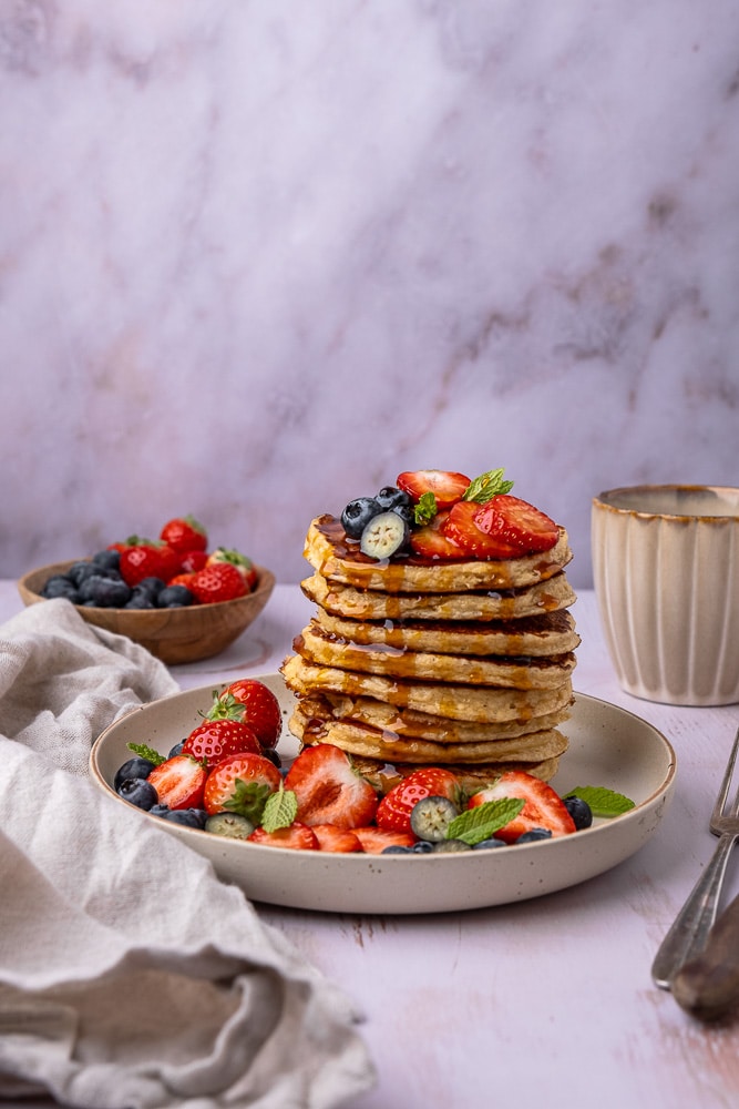 Recept voor gezonde cottage cheese pannenkoeken, gemaakt van havermout, eieren en cottage cheese, geserveerd met vers fruit als topping voor een eiwitrijk ontbijt of lunch.