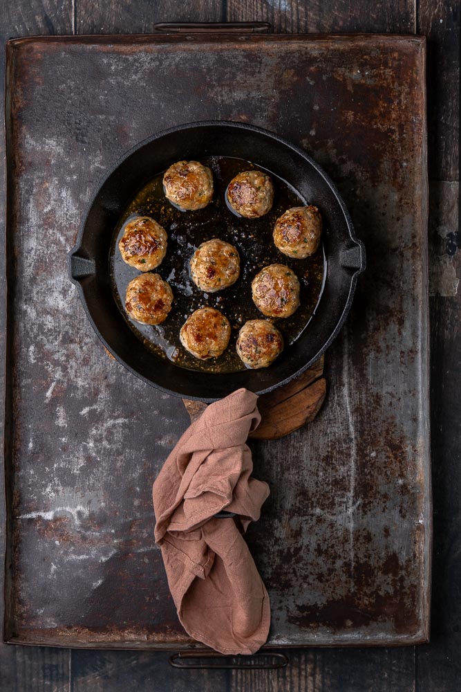 Italiaanse kipgehaktballetjes op smaak gebracht met knoflook, ui, peterselie, basilicum, oregano, zongedroogde tomaatjes en Parmezaanse kaas, geserveerd als licht en smaakvol gerecht.