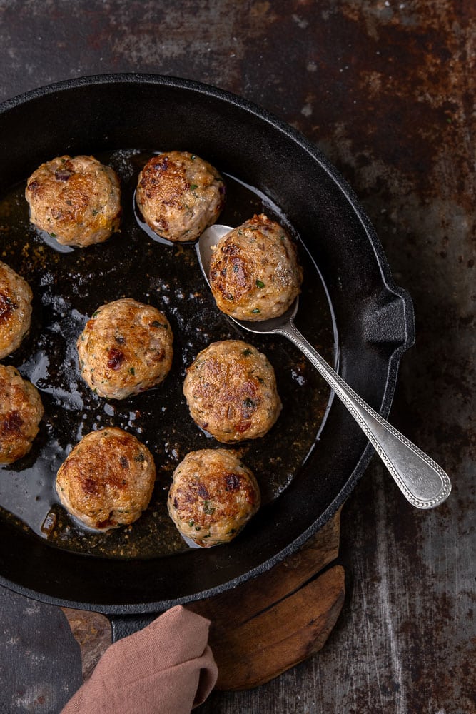 Italiaanse kipgehaktballetjes op smaak gebracht met knoflook, ui, peterselie, basilicum, oregano, zongedroogde tomaatjes en Parmezaanse kaas, geserveerd als licht en smaakvol gerecht.