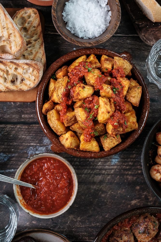 Makkelijk recept voor Patatas bravas: knapperige Spaanse aardappeltjes uit de oven met een pittige bravas saus, geserveerd als klassiek tapas gerecht.