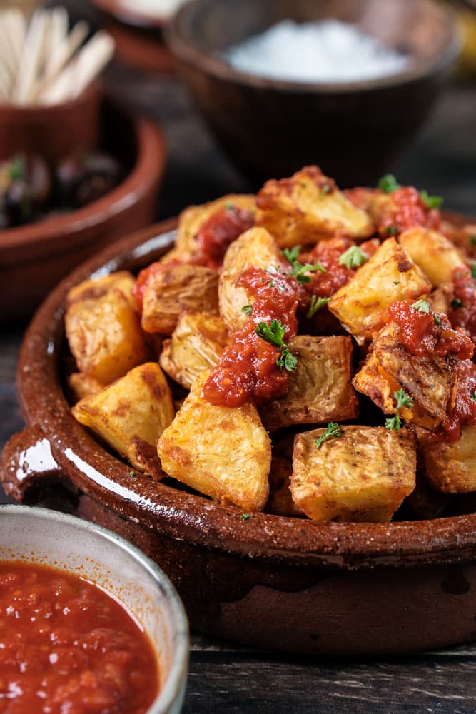 Makkelijk recept voor Patatas bravas: knapperige Spaanse aardappeltjes uit de oven met een pittige bravas saus, geserveerd als klassiek tapas gerecht.