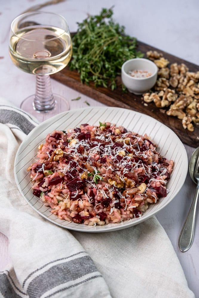 Makkelijk en gezond recept voor rode bieten risotto. een kleurrijk en smaakvol gerecht met krokante walnoten, knapperige spekjes en Parmezaanse kaas. Perfect als comfort food met een gezonde twist!