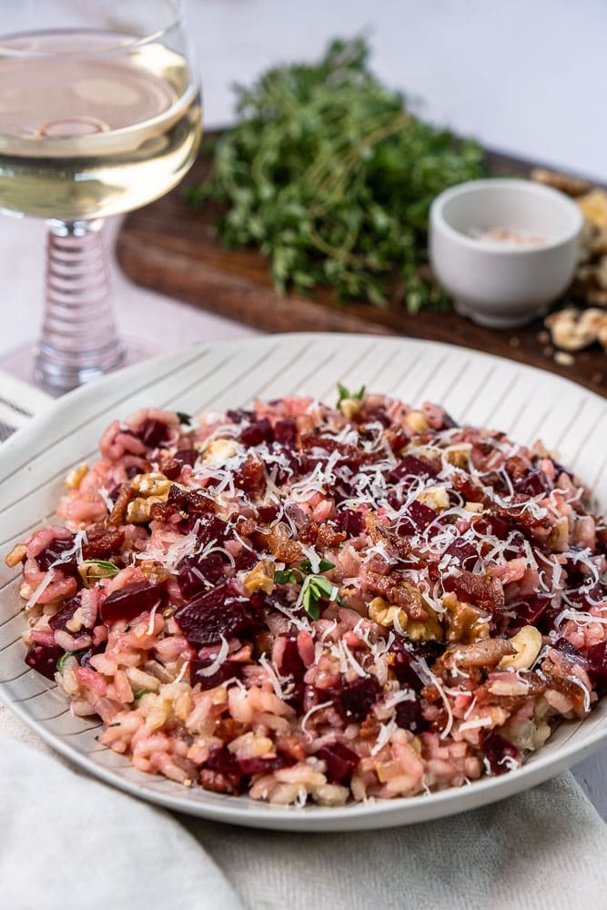 Makkelijk en gezond recept voor rode bieten risotto. een kleurrijk en smaakvol gerecht met krokante walnoten, knapperige spekjes en Parmezaanse kaas. Perfect als comfort food met een gezonde twist!