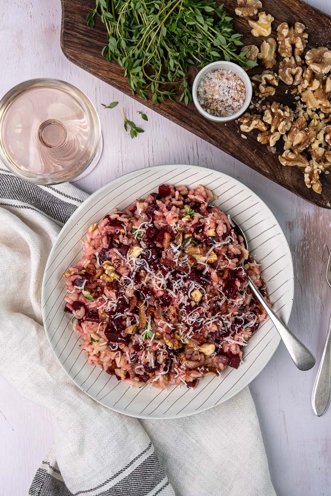 Makkelijk en gezond recept voor rode bieten risotto. een kleurrijk en smaakvol gerecht met krokante walnoten, knapperige spekjes en Parmezaanse kaas. Perfect als comfort food met een gezonde twist!