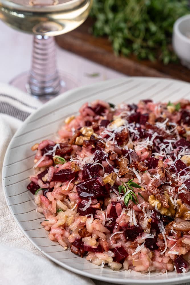 Makkelijk en gezond recept voor rode bieten risotto. een kleurrijk en smaakvol gerecht met krokante walnoten, knapperige spekjes en Parmezaanse kaas. Perfect als comfort food met een gezonde twist!