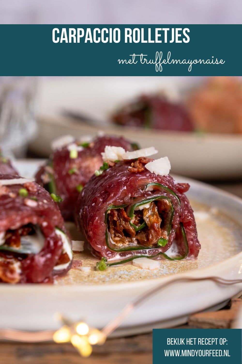 Carpaccio rolletjes met komkommer, truffelmayonaise, krokante spekkruimels, Parmezaanse kaas, zongedroogde tomaatjes, rucola en bieslook, geserveerd als feestelijk voorgerecht. Carpaccio hapje als amuse voor een Kerst diner, carpaccio koolhydraatarm voorgerecht.