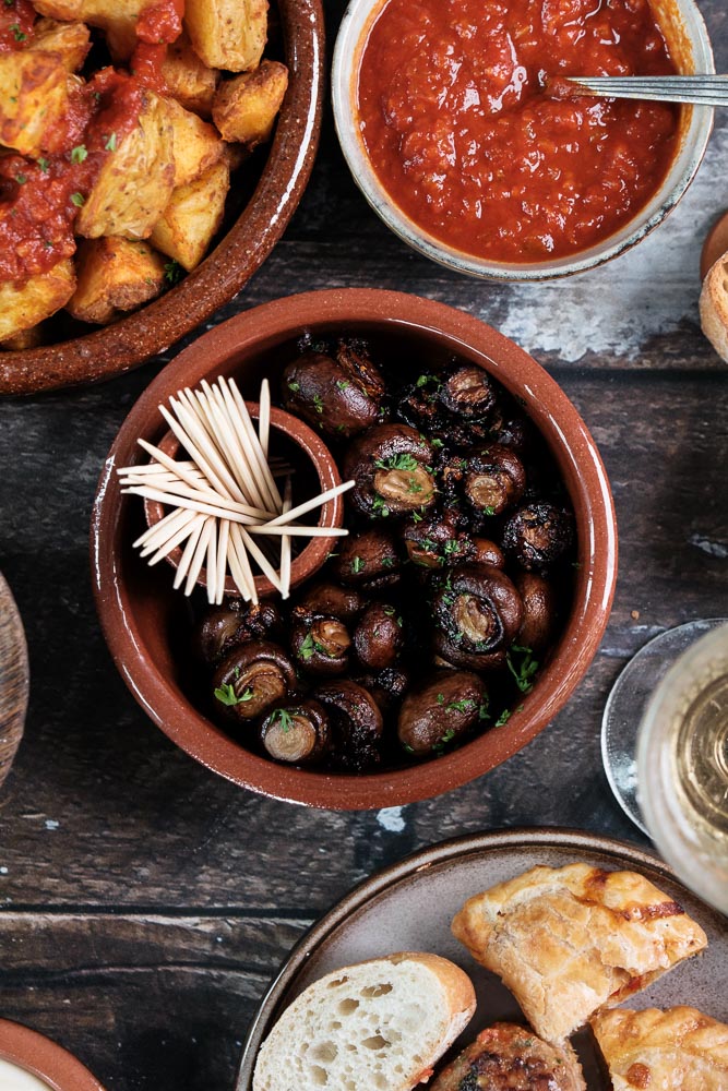 Knoflook champignons, gebakken in knoflookolie met verse peterselie en gerookt paprikapoeder, geserveerd als tapasgerecht. Tapas hapje met champignons, Champiñones al ajillo