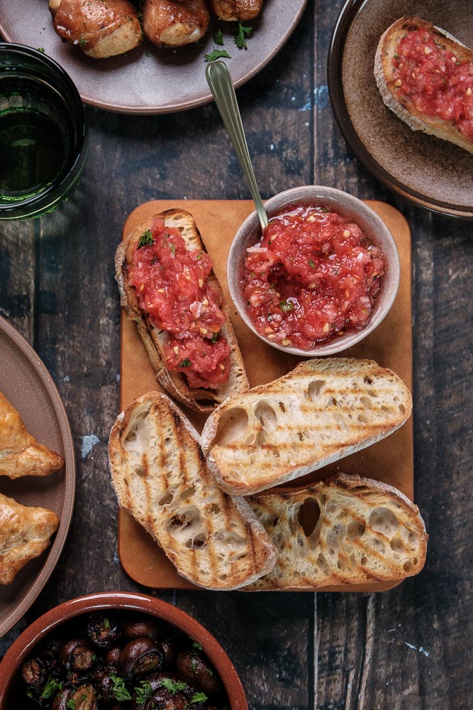 Pan con tomate, geroosterd Spaans brood met verse tomaat, knoflook en olijfolie, geserveerd als tapasgerecht. Spaans tomatenbrood, Spaanse tapas met brood. 