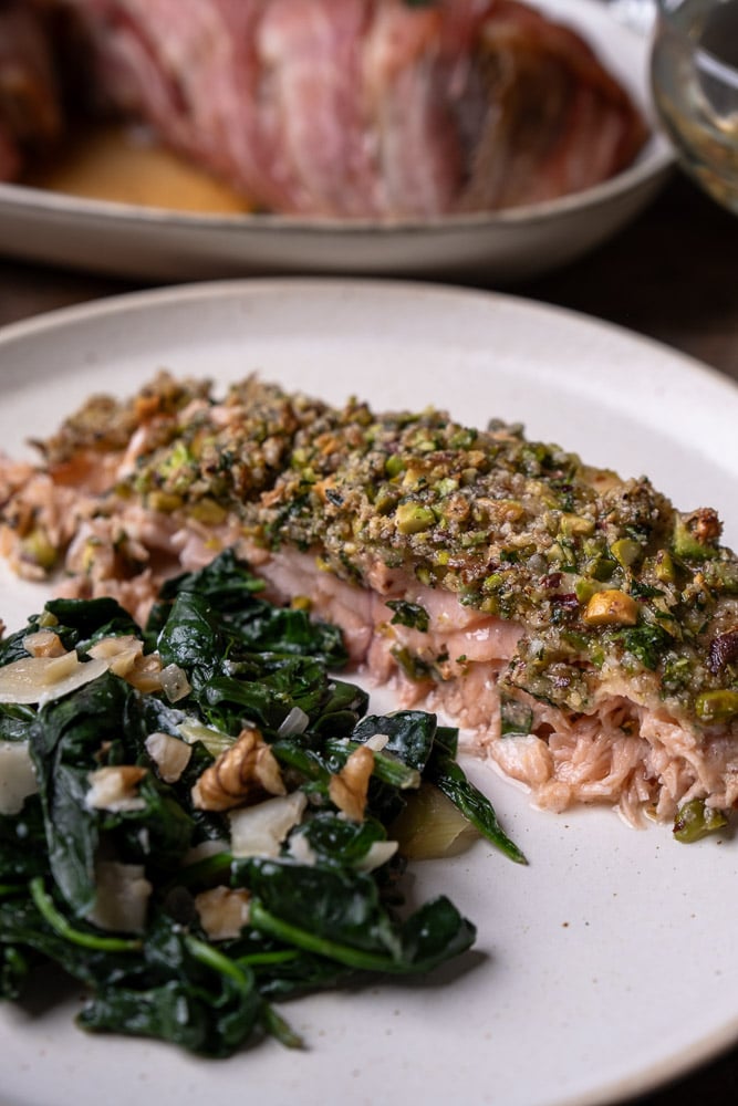 Zalm met kruidenkorst van pistache, Parmezaanse kaas, peterselie en bieslook, geserveerd als feestelijk gerecht uit de oven. Makkelijk recept voor zalm met huid, met kruidenkorst of pistache korst, lekker met pasta en gegrilde groenten.