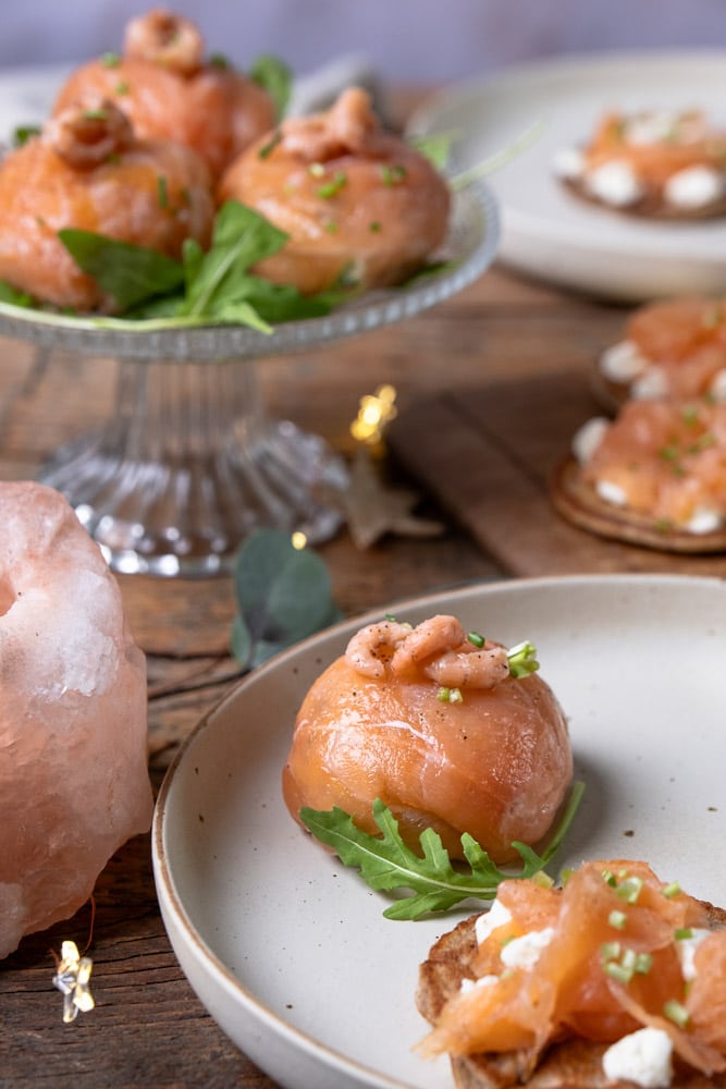 Zalmbonbons gevuld met avocado, crème fraîche, Hollandse garnalen, komkommer, bieslook en citroensap, geserveerd als feestelijk voorgerecht. Zalmbonbon recept, recept voor zalm bonbons, koolhydraatarm hapje, geserveerd als amuse of voorgerecht.