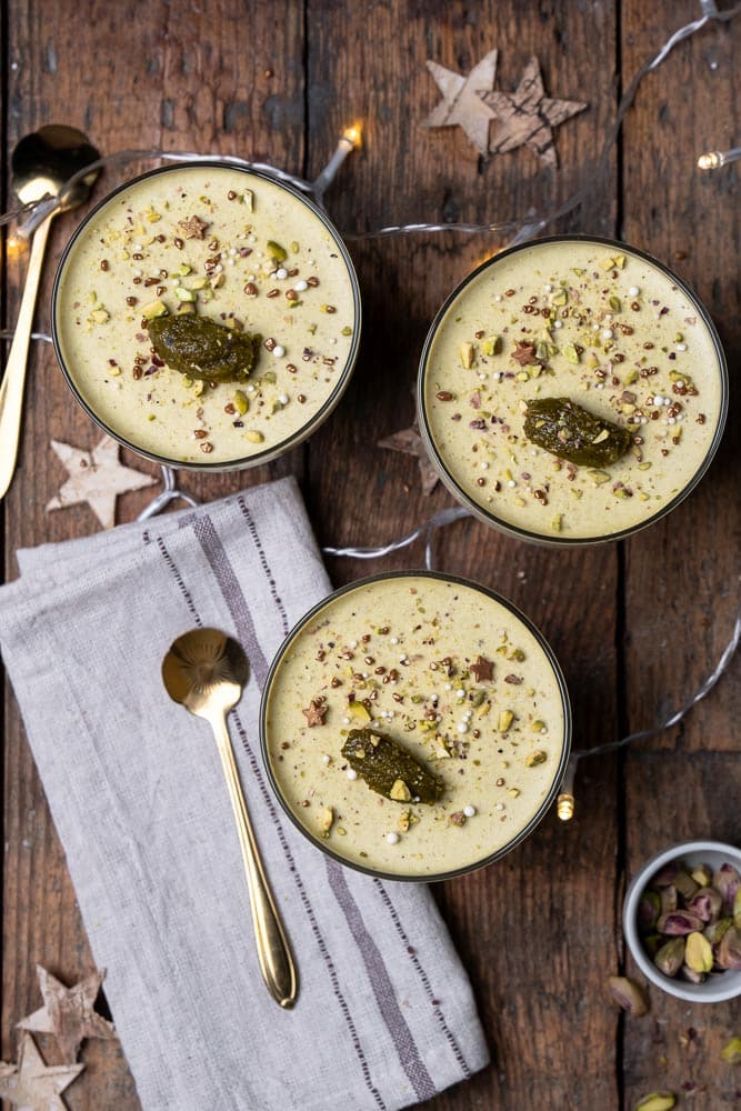 Romige pistache panna cotta, recept voor panna cotta met pistache pasta, geserveerd met een topping van fijngehakte pistachenoten, een elegant Italiaans dessert perfect voor elke gelegenheid. Feestelijk nagerecht. 