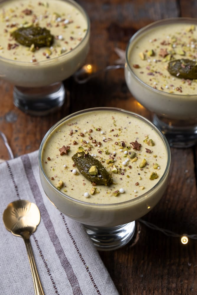 Romige pistache panna cotta, recept voor panna cotta met pistache pasta, geserveerd met een topping van fijngehakte pistachenoten, een elegant Italiaans dessert perfect voor elke gelegenheid. Feestelijk nagerecht. 