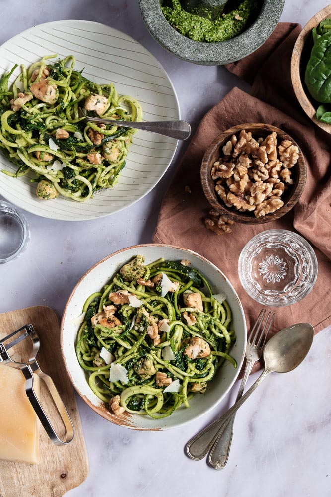 Courgette spaghetti met kip en zelfgemaakte groene pesto van spinazie en walnoten. Dit koolhydraatarme gerecht is een gezonde en smaakvolle variant op traditionele pasta pesto, boordevol groenten en eiwitten. De courgette spaghetti is eenvoudig te maken met een spiraalsnijder en wordt gecombineerd met malse kipfilet, Italiaanse kruiden en een romige pesto zonder pakjes of zakjes. Een perfect gerecht voor wie een voedzame en lichte maaltijd zoekt!