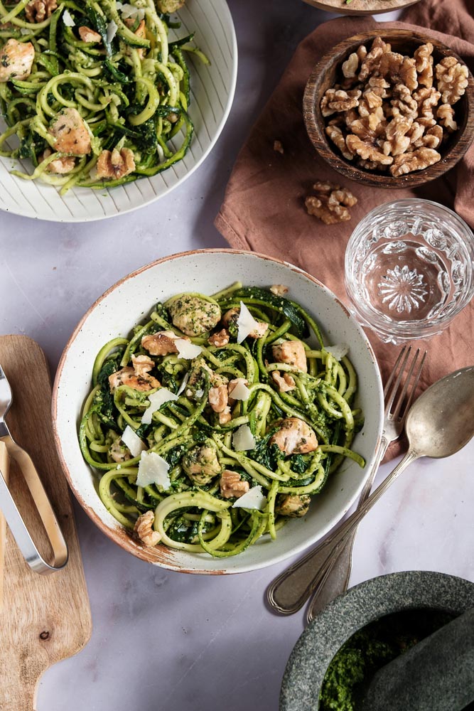 Courgette spaghetti met kip en zelfgemaakte groene pesto van spinazie en walnoten. Dit koolhydraatarme gerecht is een gezonde en smaakvolle variant op traditionele pasta pesto, boordevol groenten en eiwitten. De courgette spaghetti is eenvoudig te maken met een spiraalsnijder en wordt gecombineerd met malse kipfilet, Italiaanse kruiden en een romige pesto zonder pakjes of zakjes. Een perfect gerecht voor wie een voedzame en lichte maaltijd zoekt!