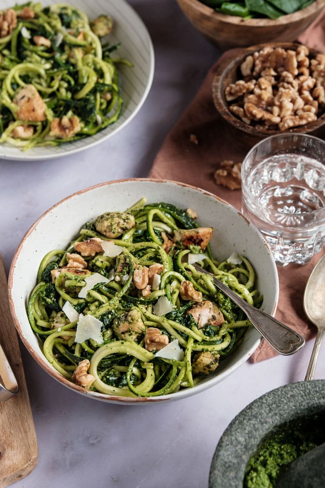 Courgette spaghetti met kip en zelfgemaakte groene pesto van spinazie en walnoten. Dit koolhydraatarme gerecht is een gezonde en smaakvolle variant op traditionele pasta pesto, boordevol groenten en eiwitten. De courgette spaghetti is eenvoudig te maken met een spiraalsnijder en wordt gecombineerd met malse kipfilet, Italiaanse kruiden en een romige pesto zonder pakjes of zakjes. Een perfect gerecht voor wie een voedzame en lichte maaltijd zoekt!