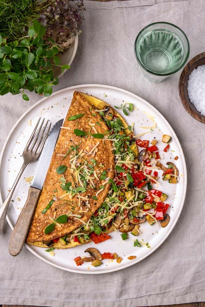 Omelet met groenten, groenten omelet gevuld met paprika, champignons en spinazie. Een voedzaam en eiwitrijk gerecht dat perfect is als lunch, ontbijt of snelle avondmaaltijd. Ook bekend als boerenomelet en ideaal om mee te nemen als makkelijk lunchgerecht op werk. Groenteomelet, groenten omelet, omelet groenten.