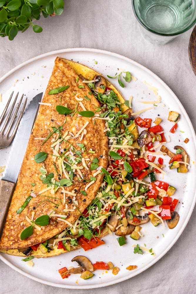 Omelet met groenten, groenten omelet gevuld met paprika, champignons en spinazie. Een voedzaam en eiwitrijk gerecht dat perfect is als lunch, ontbijt of snelle avondmaaltijd. Ook bekend als boerenomelet en ideaal om mee te nemen als makkelijk lunchgerecht op werk. Groenteomelet, groenten omelet, omelet groenten.